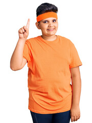 Little boy kid wearing sportswear showing and pointing up with finger number one while smiling confident and happy.