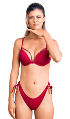 Obraz premium Young beautiful woman wearing bikini cutting throat with hand as knife, threaten aggression with furious violence