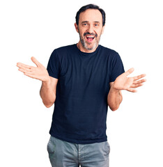 Naklejka premium Middle age handsome man wearing casual t-shirt clueless and confused expression with arms and hands raised. doubt concept.