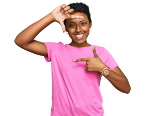 Young african american woman wearing casual clothes smiling making frame with hands and fingers with happy face. creativity and photography concept.