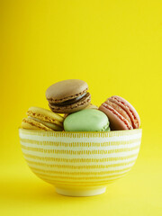Close up, macarons of various flavors, typical French sweet.
Yellow background and copy space.