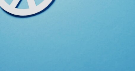 Close up of white peace sign and copy space on blue background