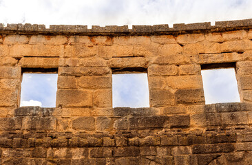 ancient wall of historical building with three windows, old construction on medioeval history outdoor