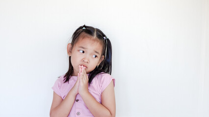 Cute kid putting his hands together as if begging for something, sadness feel.