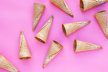 Empty ice cream cone on pink background.