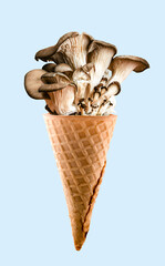 Mushrooms in waffle cone on blue background. Concept of unusual ice cream tastes.