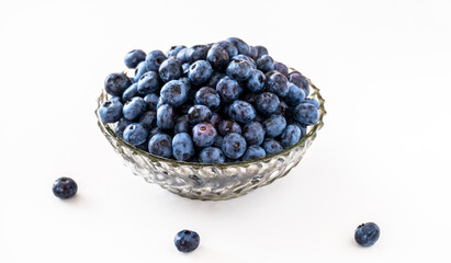 Blueberry in vintage glass plate on white table.