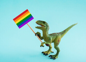 Cute dinosaur holding sign with rainbow flag on blue background.
