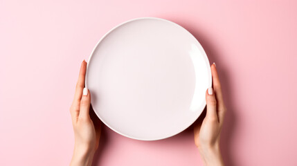 Empty plate, hands holding, top view, isolated on pink background