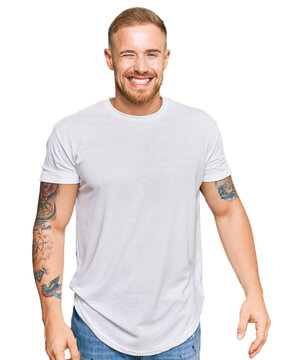 Young irish man wearing casual clothes winking looking at the camera with sexy expression, cheerful and happy face.