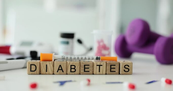 Diabetes text with syringe and pills on table in clinic. Diseases of endocrine system caused high blood sugar