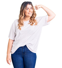 Fototapeta premium Young caucasian woman wearing casual clothes smiling pointing to head with one finger, great idea or thought, good memory