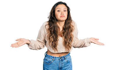 Young hispanic girl wearing casual clothes clueless and confused with open arms, no idea and...