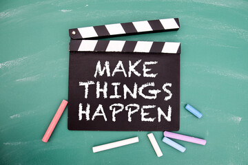 Make things happen. Motivational reminder text on a chalk board film clapper
