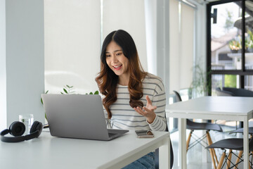 Young woman engaged in online study, video call, project work.