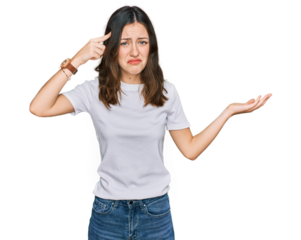 Young beautiful woman wearing casual white t shirt confused and annoyed with open palm showing copy space and pointing finger to forehead. think about it.