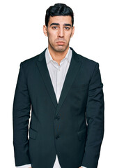 Handsome hispanic man wearing business clothes depressed and worry for distress, crying angry and afraid. sad expression.