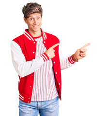 Young handsome man wearing baseball uniform pointing aside worried and nervous with both hands,...