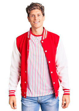 Young handsome man wearing baseball uniform with a happy and cool smile on face. lucky person.