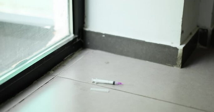 Used medical syringe with needle was thrown on floor. Disposal of disposable syringes and needles after use