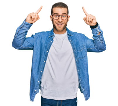 Young caucasian man wearing casual clothes smiling amazed and surprised and pointing up with fingers and raised arms.