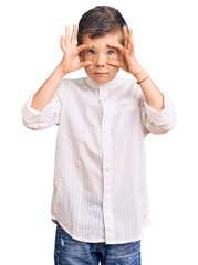 Cute blond kid wearing elegant shirt trying to open eyes with fingers, sleepy and tired for morning fatigue