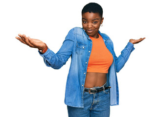 Young african american woman wearing casual clothes clueless and confused expression with arms and...