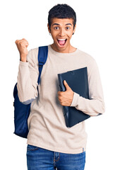 Young african amercian man wearing student backpack holding binder screaming proud, celebrating...