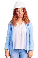 Young latin woman wearing architect hardhat depressed and worry for distress, crying angry and afraid. sad expression.