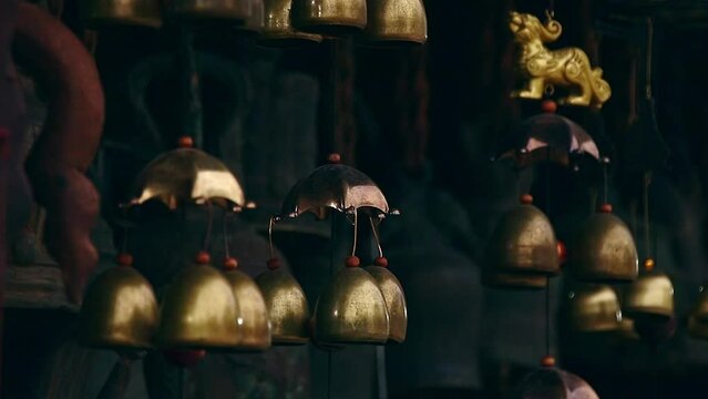 Hanging brass wind chimes or feng shui bells believed to bring luck and wellness in the home 