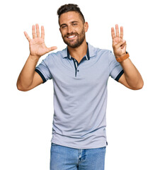Fototapeta premium Handsome man with beard wearing casual clothes showing and pointing up with fingers number eight while smiling confident and happy.