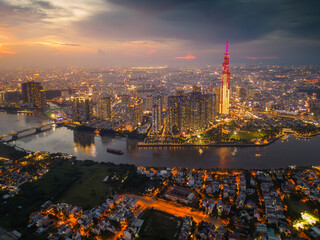 Obraz premium Aerial view of a Ho Chi Minh City, Vietnam with development buildings, transportation, energy power infrastructure. Financial and business centers. Sunset to night.