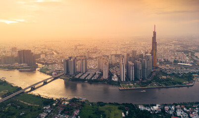 Aerial view of a Ho Chi Minh City, Vietnam with development buildings, transportation, energy power infrastructure. Financial and business centers. Sunset to night.
