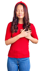 Naklejka premium Young beautiful chinese girl wearing casual clothes and diadem smiling with hands on chest with closed eyes and grateful gesture on face. health concept.