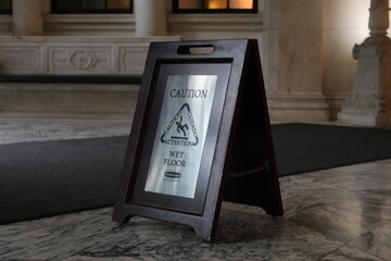 A photo of a caution sign folded onto a marble floor in Philadelphia, USA. 