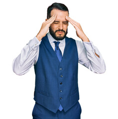 Young man with beard wearing business vest with hand on head for pain in head because stress. suffering migraine.