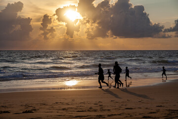 People running at sunset on Phuket beach