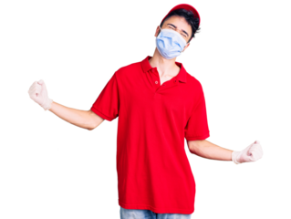 Young hispanic man wearing delivery uniform and medical mask very happy and excited doing winner gesture with arms raised, smiling and screaming for success. celebration concept.