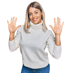 Beautiful blonde woman wearing casual turtleneck sweater showing and pointing up with fingers number ten while smiling confident and happy.