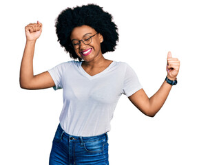 Young african american woman wearing casual white t shirt dancing happy and cheerful, smiling moving casual and confident listening to music