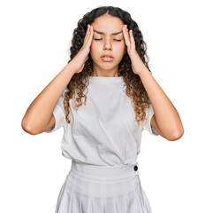 Teenager hispanic girl wearing casual white t shirt suffering from headache desperate and stressed because pain and migraine. hands on head.