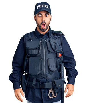 Young hispanic man wearing police uniform afraid and shocked with surprise and amazed expression, fear and excited face.