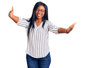 Young african american woman wearing casual clothes and glasses looking at the camera smiling with open arms for hug. cheerful expression embracing happiness.
