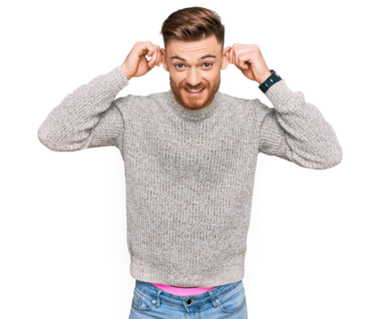 Young redhead man wearing casual winter sweater smiling pulling ears with fingers, funny gesture. audition problem