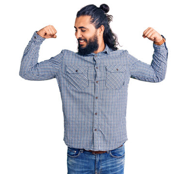 Young arab man wearing casual clothes showing arms muscles smiling proud. fitness concept.