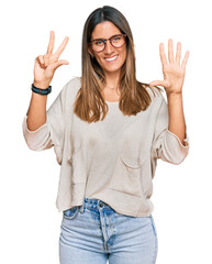 Young woman wearing casual clothes and glasses showing and pointing up with fingers number eight while smiling confident and happy.