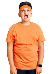 Little boy kid wearing sportswear angry and mad screaming frustrated and furious, shouting with anger. rage and aggressive concept.