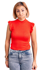 Obraz premium Young blonde woman wearing casual clothes puffing cheeks with funny face. mouth inflated with air, crazy expression.