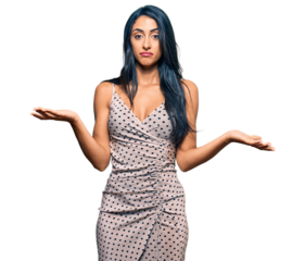 Beautiful hispanic woman wearing summer dress clueless and confused expression with arms and hands raised. doubt concept.