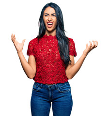 Beautiful hispanic woman wearing elegant shirt crazy and mad shouting and yelling with aggressive expression and arms raised. frustration concept.